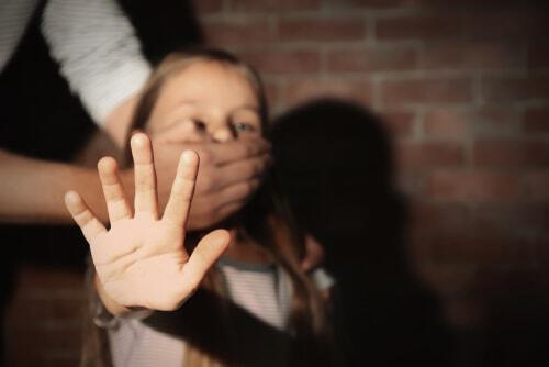 Girl in white shirt with hand over her mouth